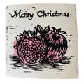 Handgemachte Linoldruck-Weihnachtskarte mit Granatapfelmotiv und der Aufschrift ‚Merry Christmas‘ in Schwarz und Rosa.
